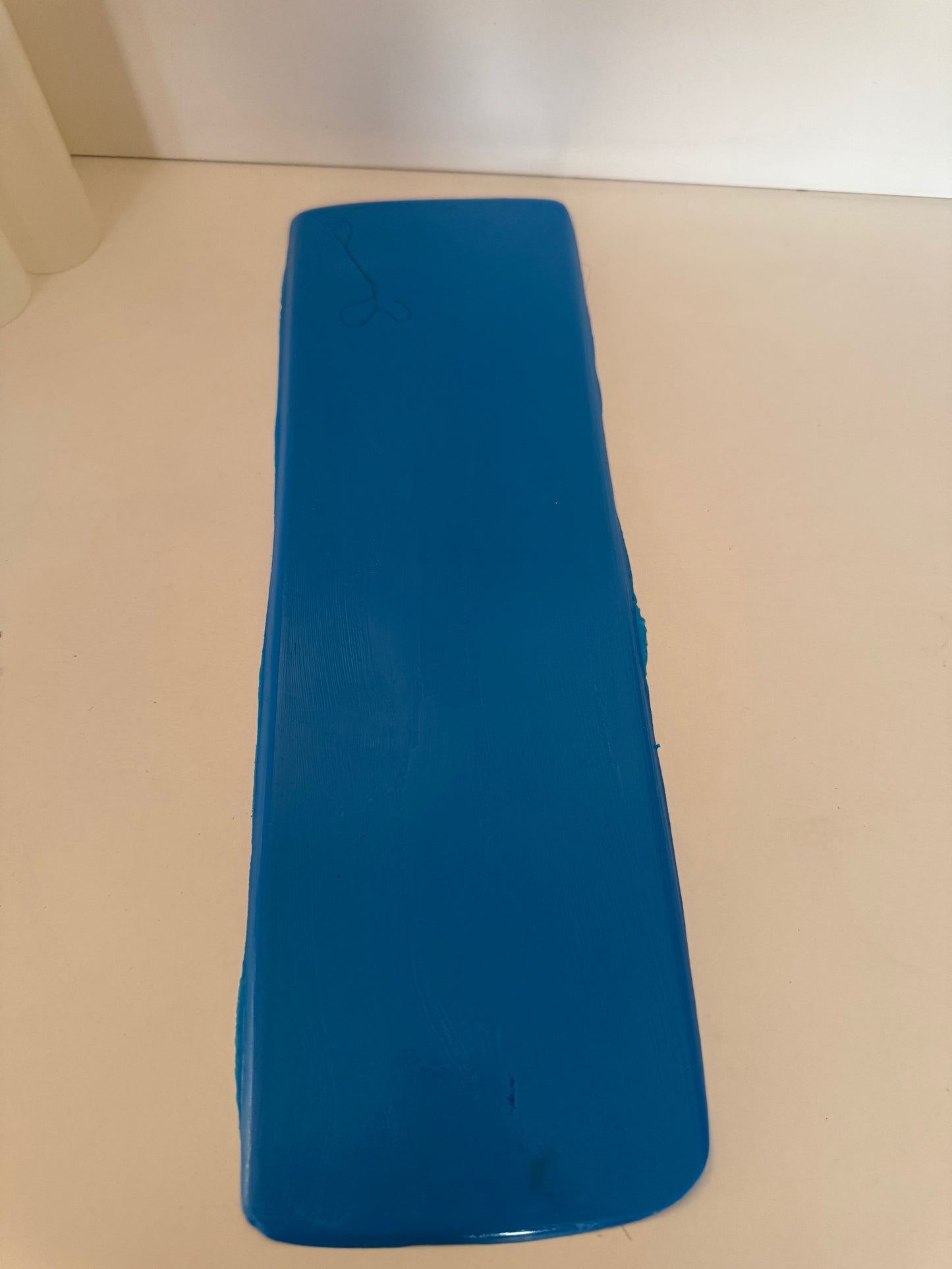 Support en caoutchouc incurvé pour l'injection de mèches de cheveux sur une micro-peau en vue de la fabrication de prothèses capillaires.