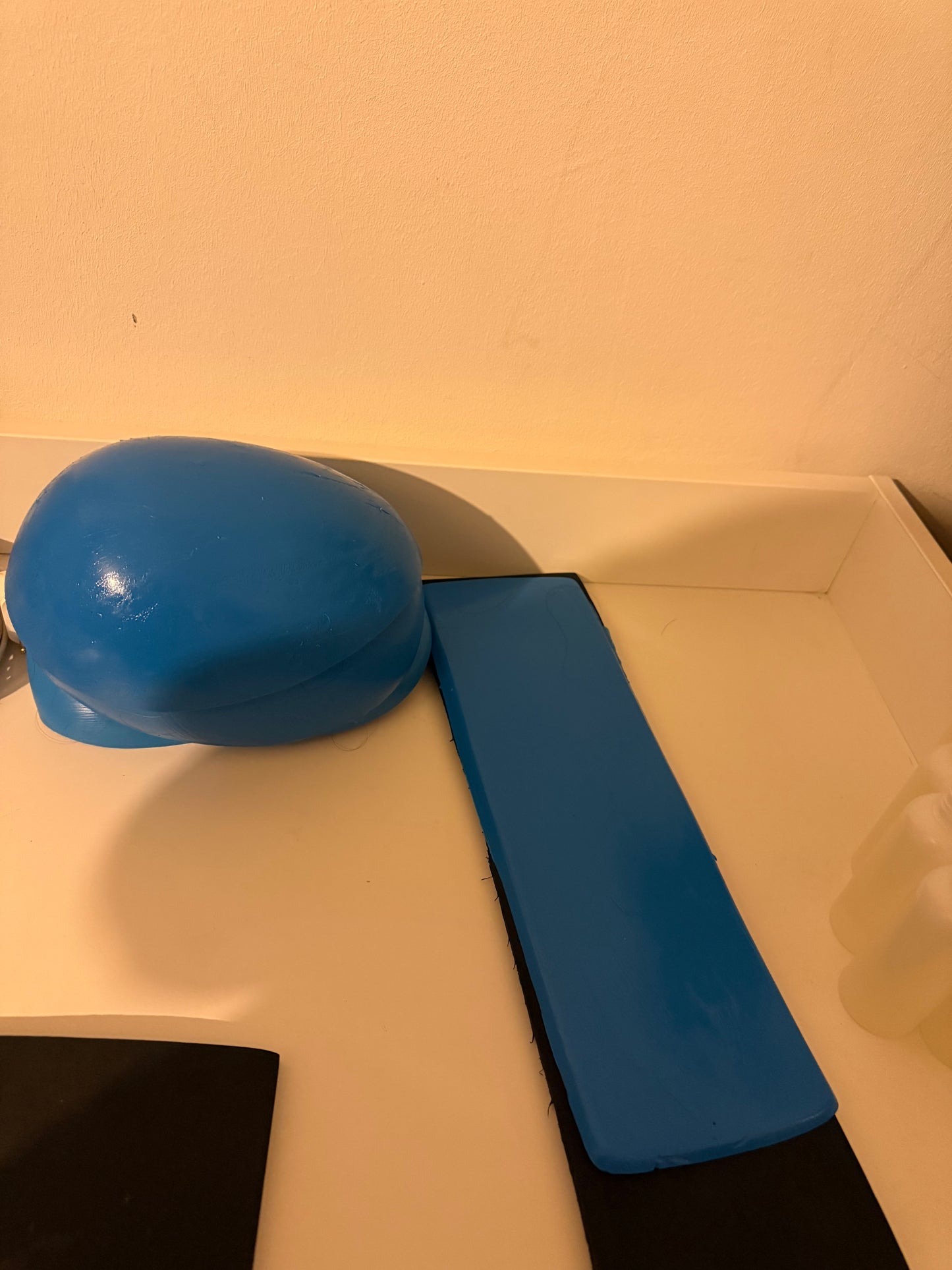 Support en caoutchouc incurvé pour l'injection de mèches de cheveux sur une micro-peau en vue de la fabrication de prothèses capillaires.