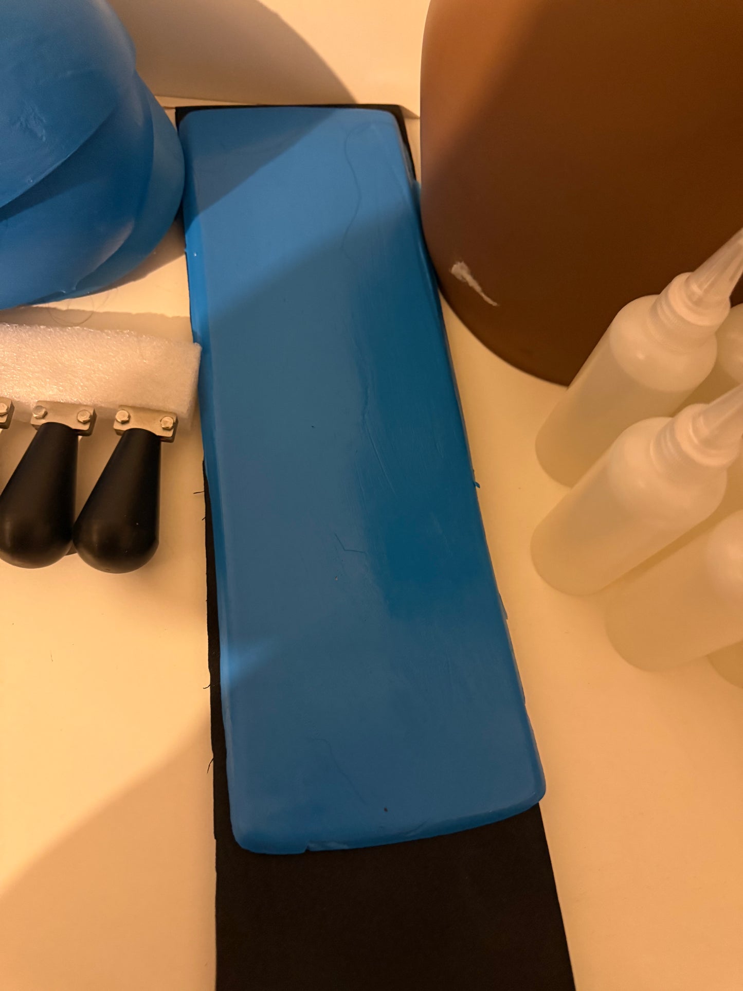 Support en caoutchouc incurvé pour l'injection de mèches de cheveux sur une micro-peau en vue de la fabrication de prothèses capillaires.